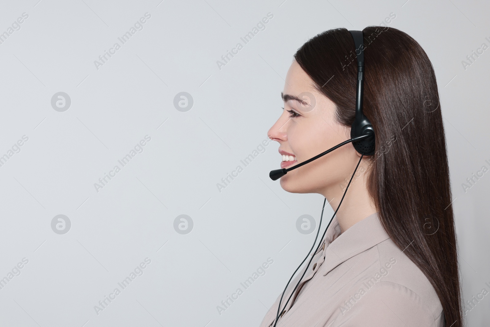 Photo of Hotline operator with modern headset on light grey background, space for text. Customer support