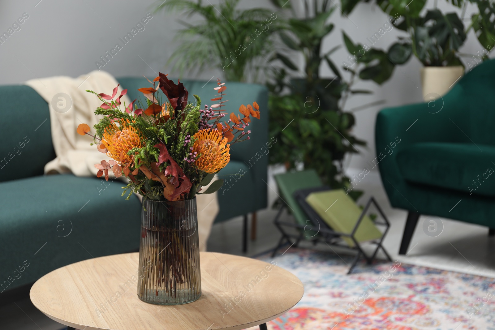 Photo of Vase with bouquet of beautiful flowers on table in living room, space for text