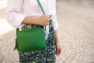 Photo of Woman with stylish green bag on city street, closeup