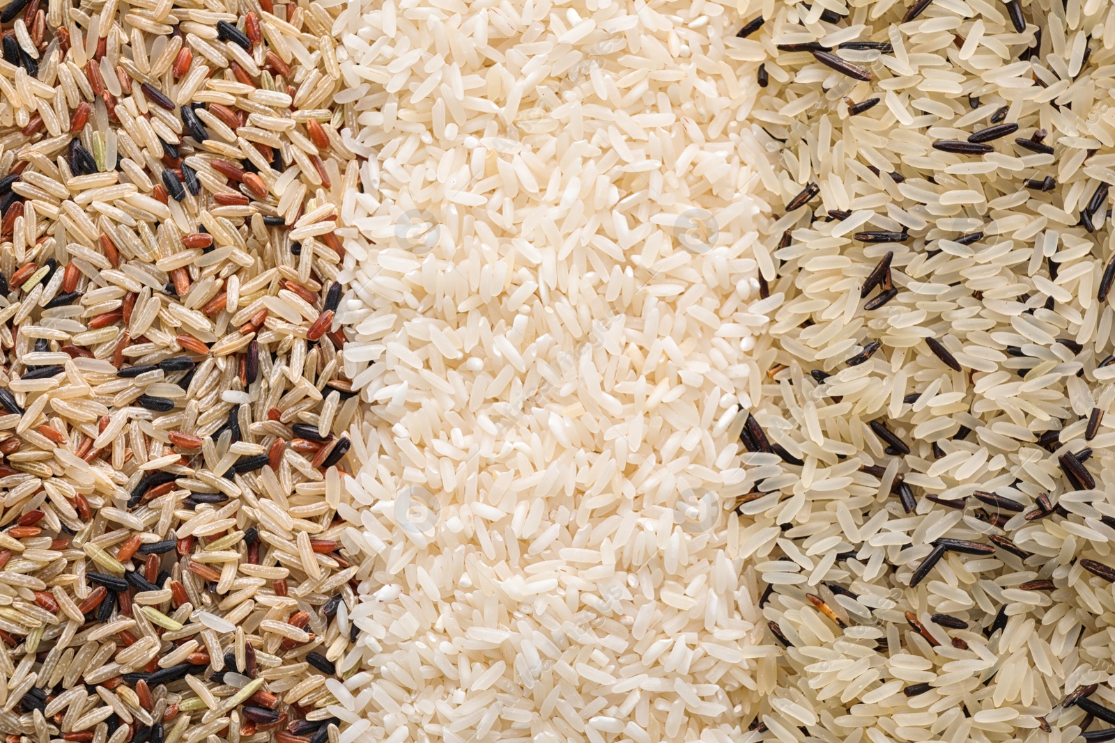 Photo of Different types of rice as background, top view