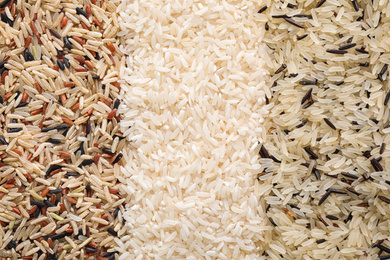 Photo of Different types of rice as background, top view