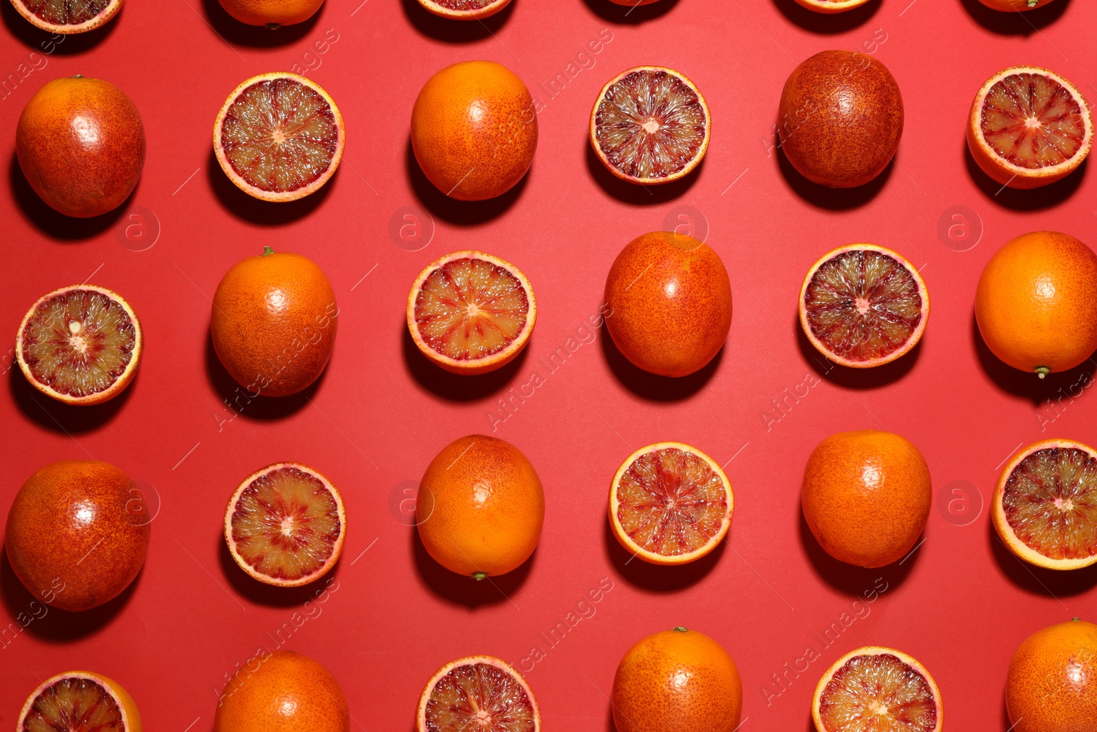 Photo of Many ripe sicilian oranges on red background, flat lay