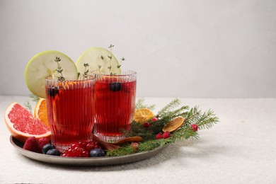 Photo of Aromatic Christmas Sangria in glasses served on light textured table, space for text