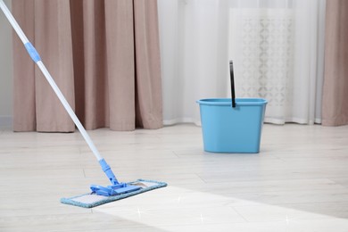 Image of Washing floor with mop in room, space for text. Clean trace on dirty surface