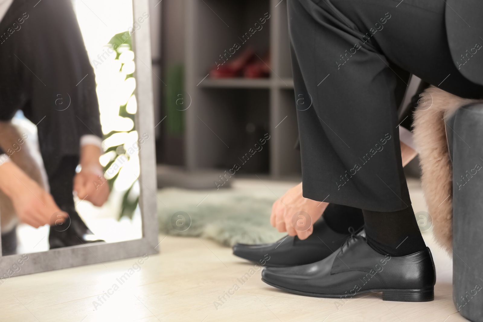 Photo of Young man trying on shoes in store