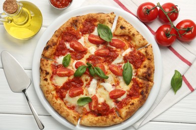 Delicious Margherita pizza, tomatoes, sauce, oil and server on white wooden table, top view