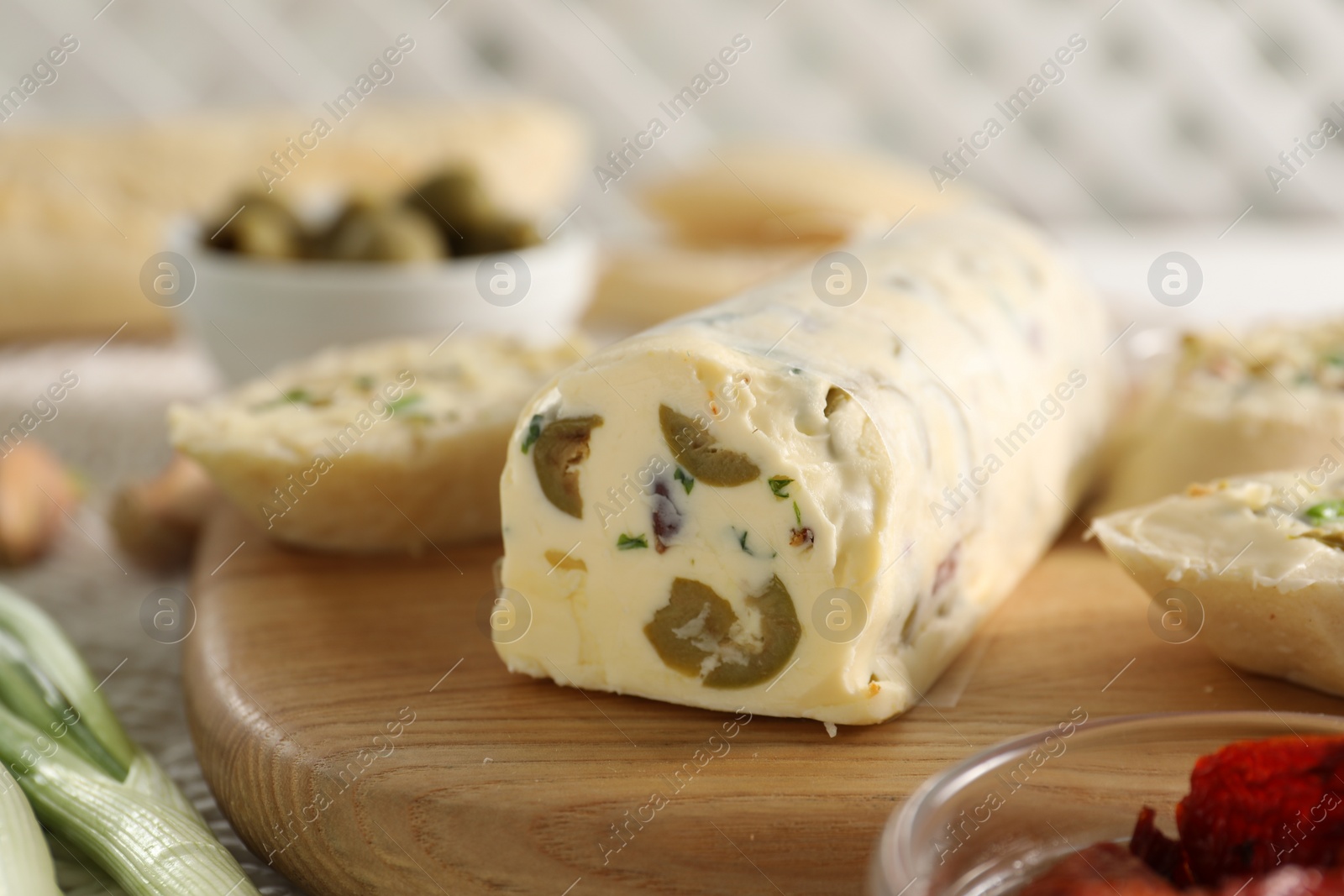 Photo of Tasty butter with olives and green onion on table, closeup