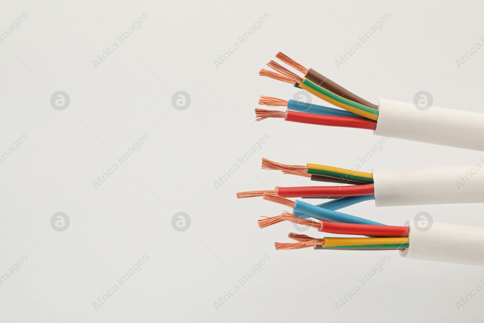 Photo of Electrical wires on white background, closeup view