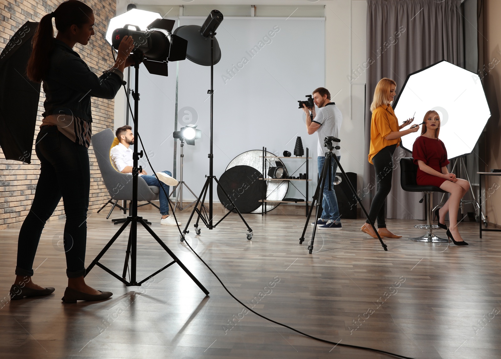 Photo of Photo studio with professional equipment and team of workers