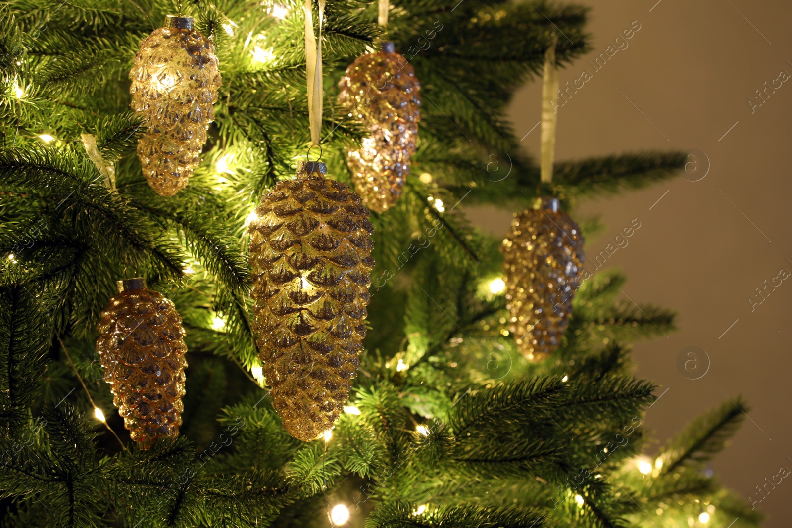 Photo of Christmas tree decorated with holiday baubles and fairy lights, closeup