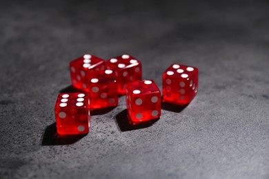 Photo of Many red game dices on grey textured table