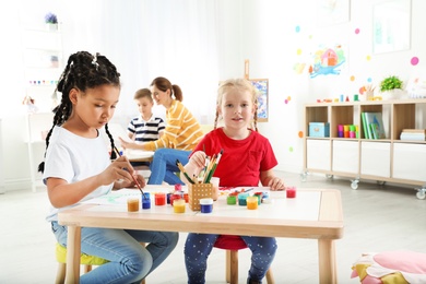 Photo of Cute little children painting at lesson indoors