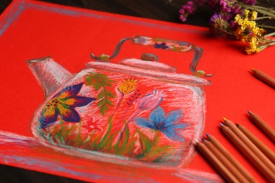 Photo of Colorful pastel pencils, flowers and beautiful painting of kettle on table