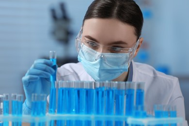 Scientist holding test tube with sample in laboratory