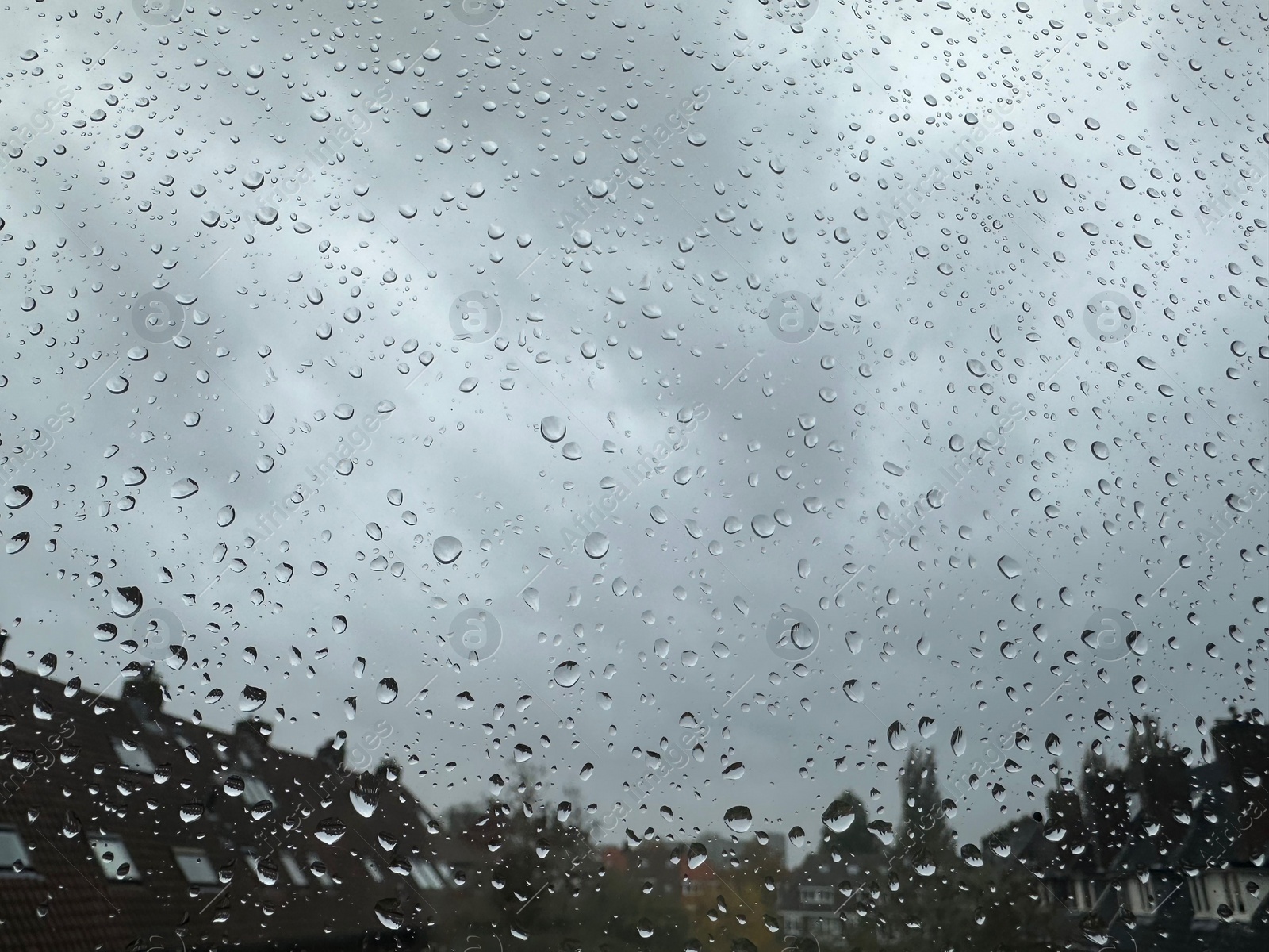 Photo of Window with water droplets on rainy day, closeup