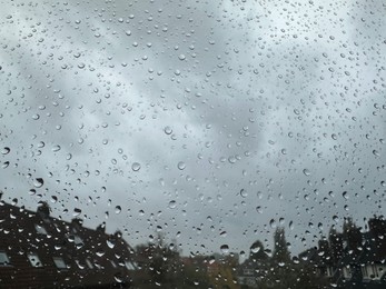 Window with water droplets on rainy day, closeup