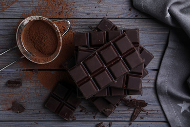 Flat lay composition with dark chocolate on wooden table