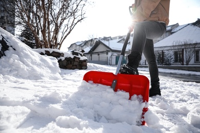 Photo of Person shoveling snow outdoors on winter day, closeup