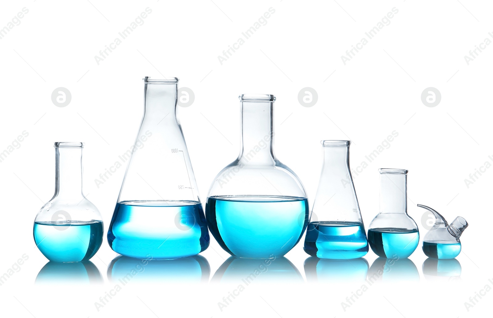 Photo of Laboratory glassware for chemical analysis with blue liquid on table against white background