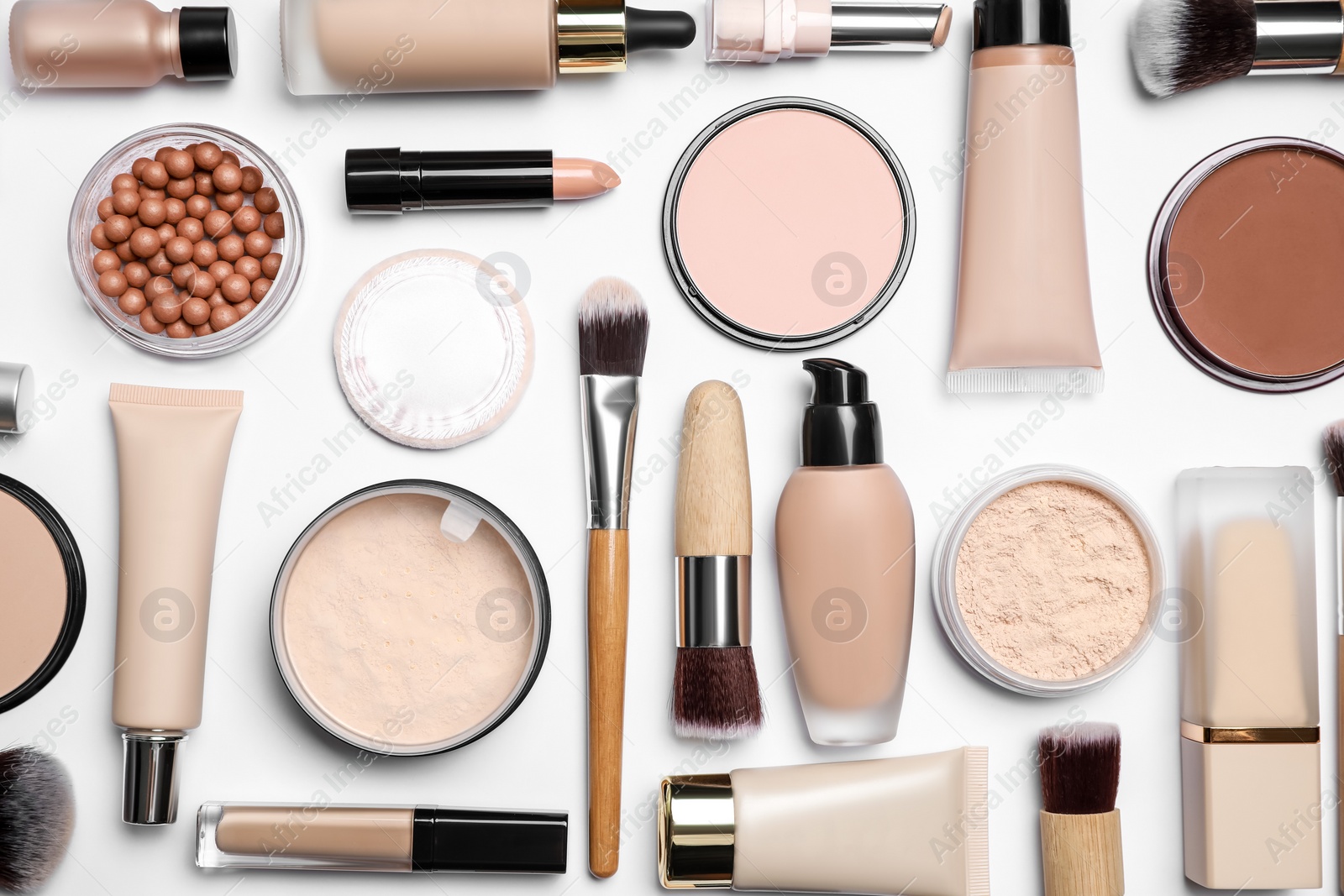 Photo of Face powders and other makeup products on white background, flat lay