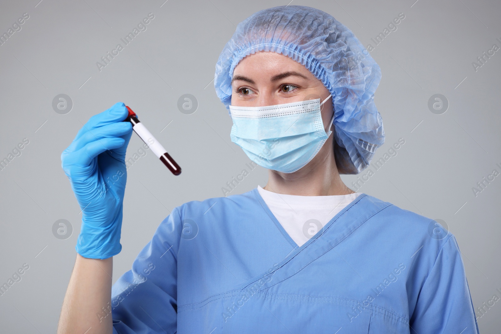 Photo of Laboratory testing. Doctor with blood sample in tube on light grey background