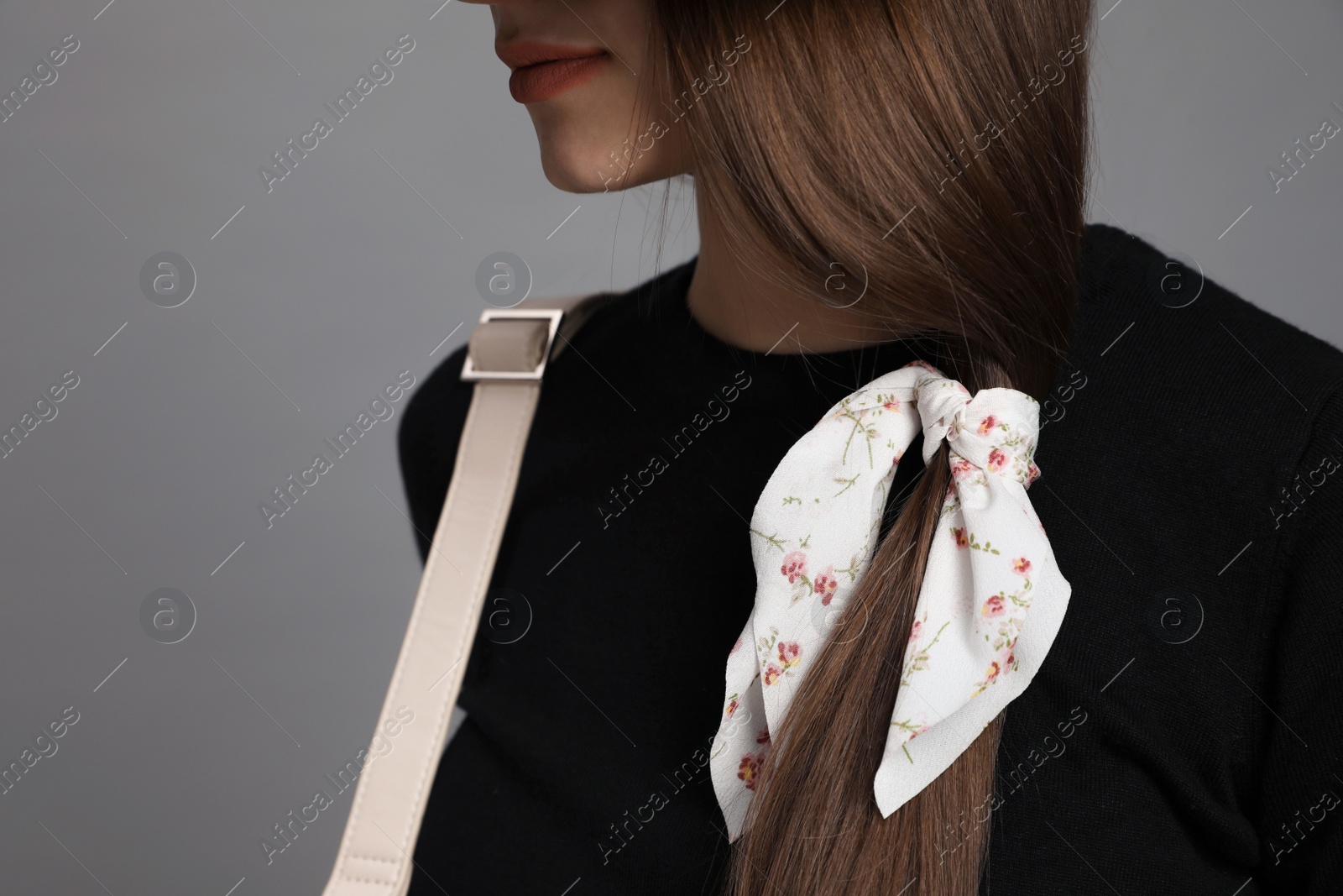 Photo of Young woman with stylish bandana on grey background, closeup