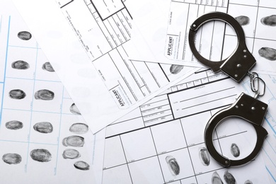 Photo of Handcuffs and fingerprint record sheets, top view. Criminal investigation