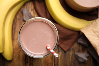 Fresh yummy chocolate milk on wooden table, flat lay