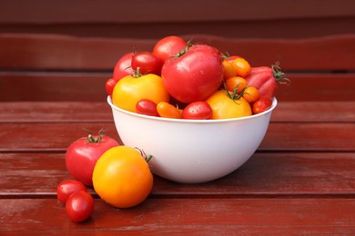 Photo of Bowl with fresh tomatoes on wooden surface