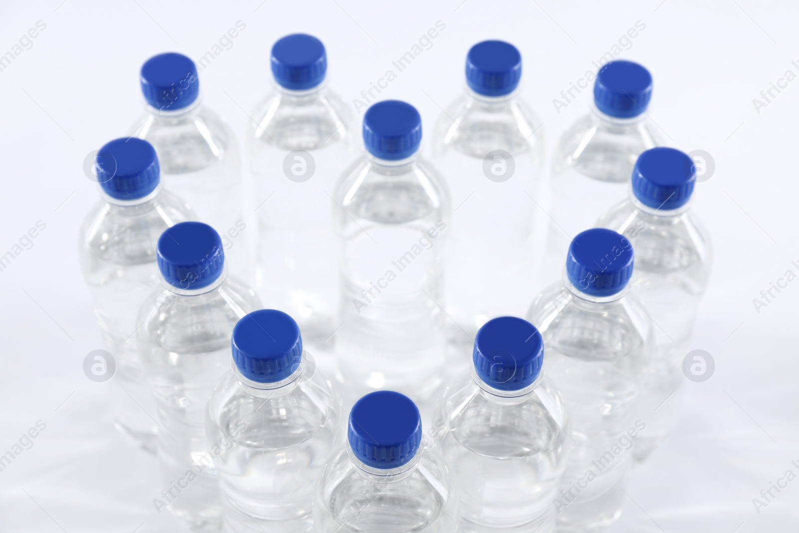 Photo of Heart made with plastic bottles of pure water on white background