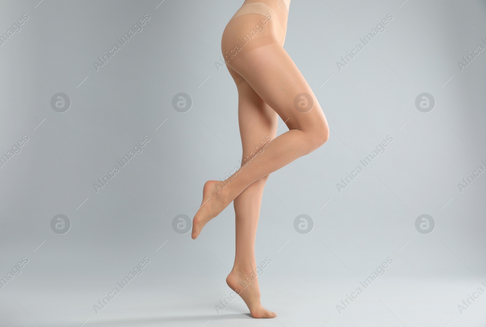 Photo of Woman wearing tights on light grey background, closeup of legs