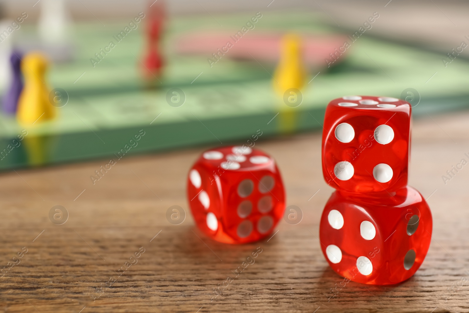 Photo of Closeup view of dices on wooden table, space for text. Board game