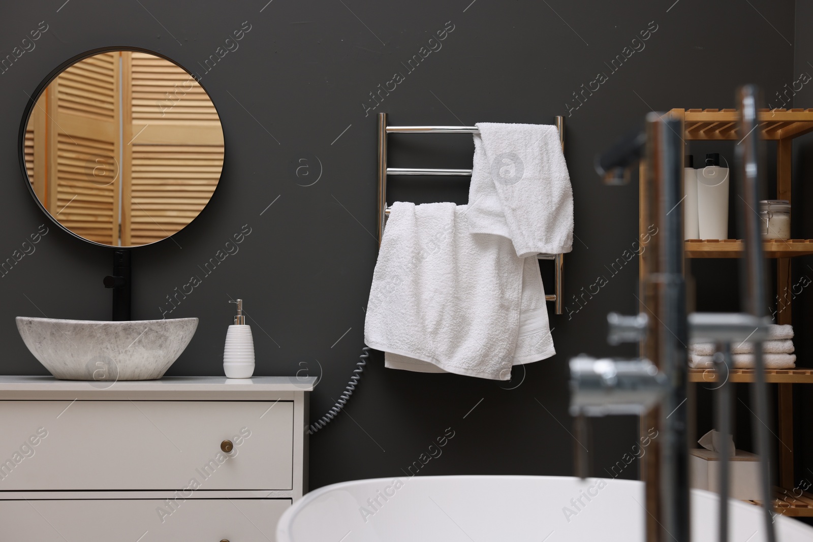 Photo of Stylish bathroom interior with heated towel rail and modern furniture