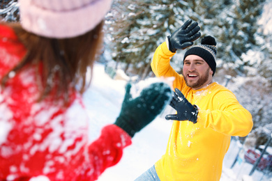 Photo of Happy couple playing snowballs outdoors. Winter vacation