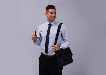 Businessman with stylish leather briefcase on light grey background