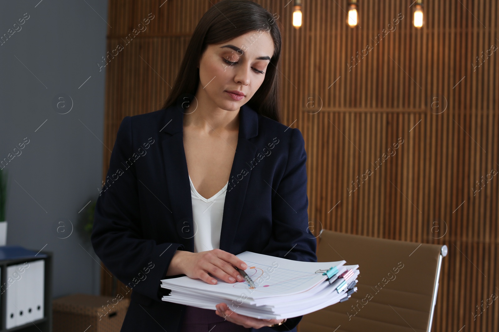 Photo of Beautiful businesswoman working with documents in office