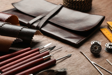 Photo of Leather samples and tools on brown table, closeup