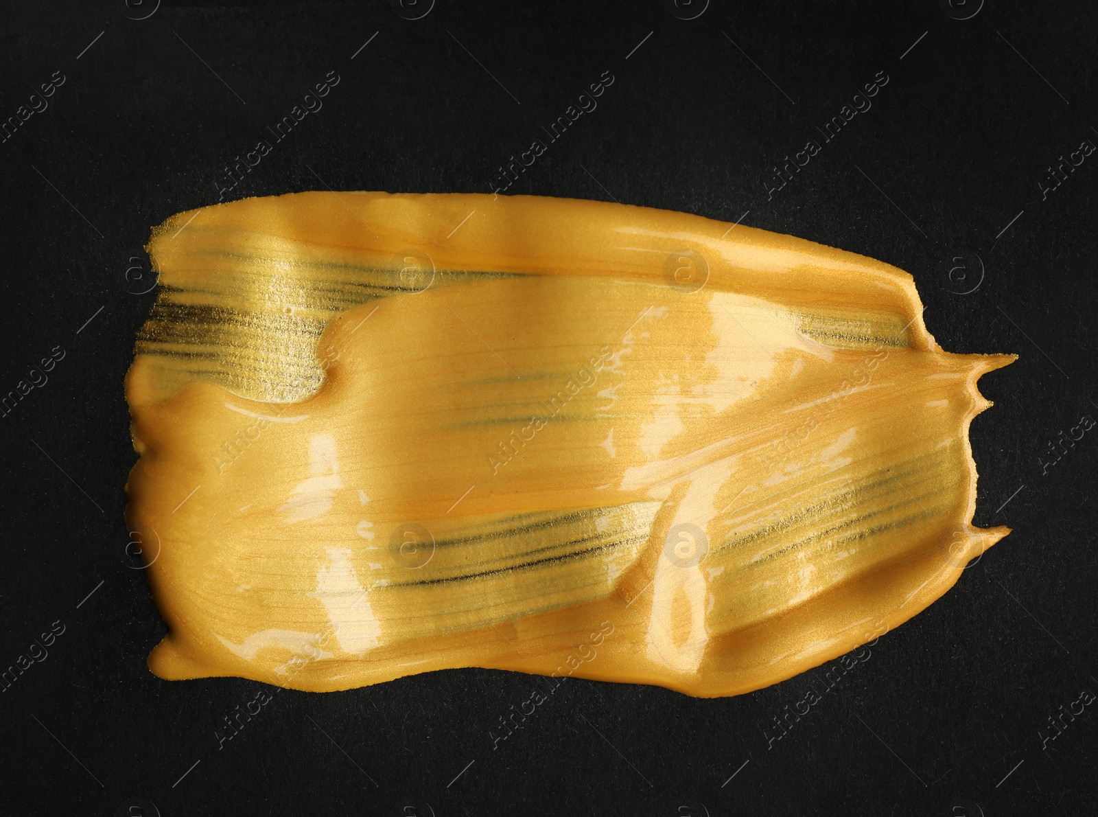 Photo of Golden paint brush strokes on black background