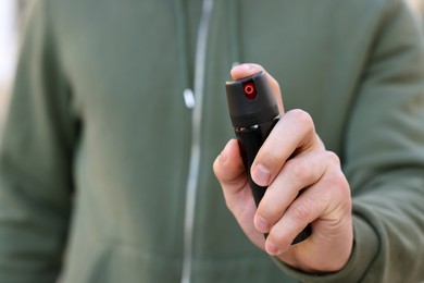 Photo of Man using pepper spray, closeup. Space for text