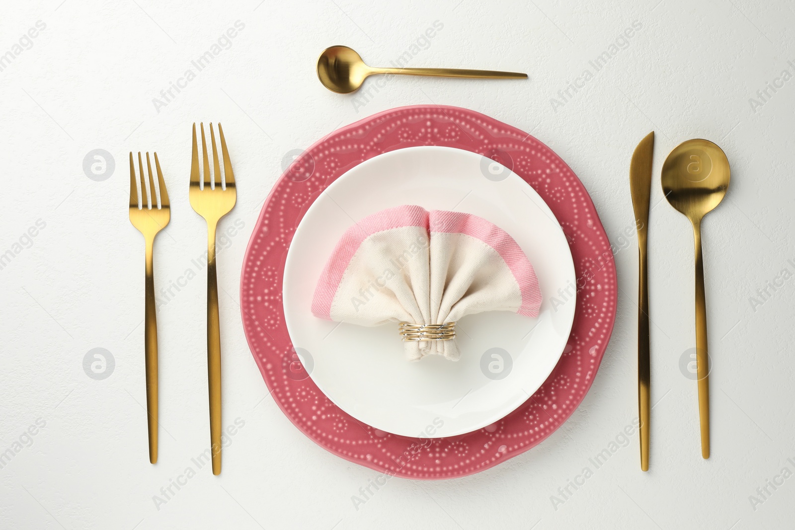 Photo of Stylish setting with cutlery, napkin and plates on white textured table, flat lay