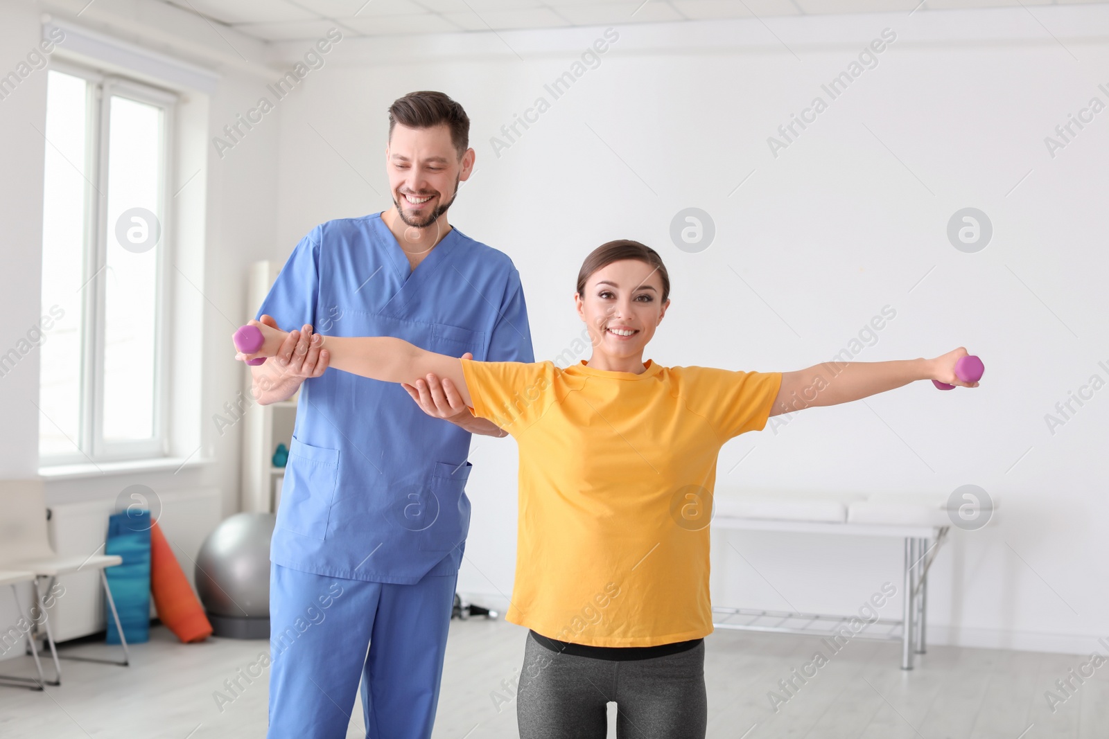 Photo of Physiotherapist working with female patient in clinic