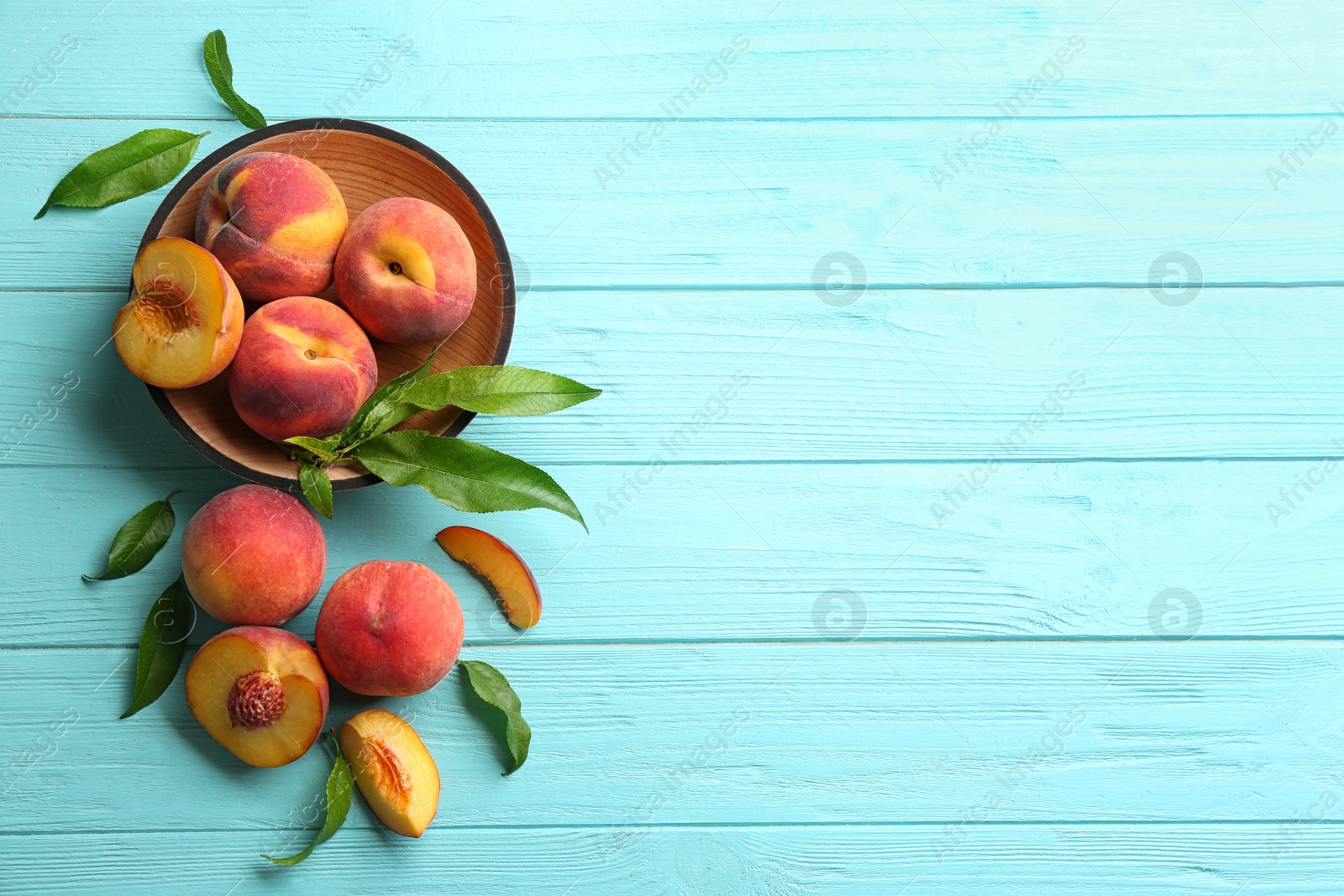 Photo of Fresh sweet peaches on turquoise wooden table, flat lay. Space for text