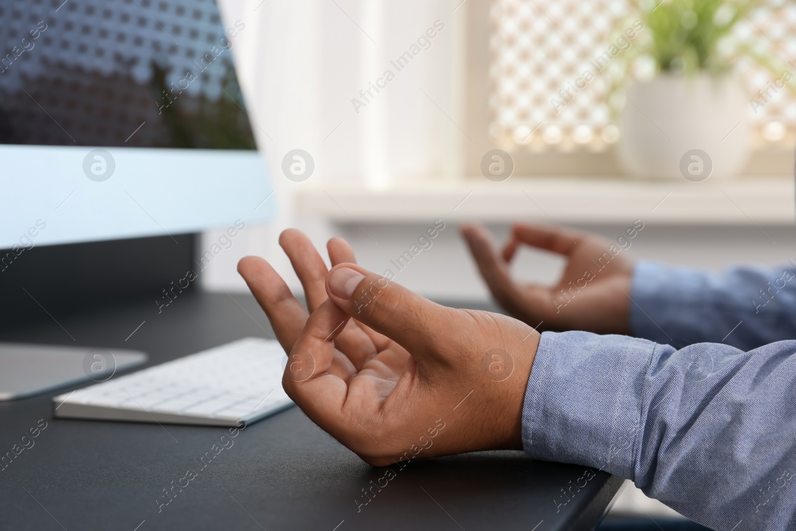 Photo of Businessman meditating at workplace, closeup. Zen concept