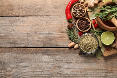 Photo of Flat lay composition with different natural spices and herbs on wooden table, space for text