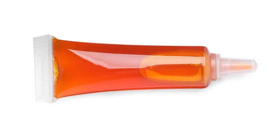 Photo of Tube with orange food coloring isolated on white, top view