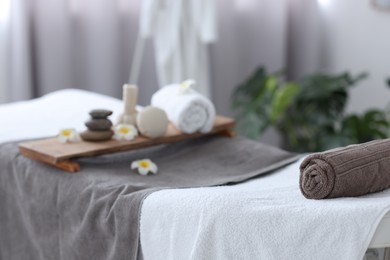 Rolled towel and spa products on massage table in recreational center