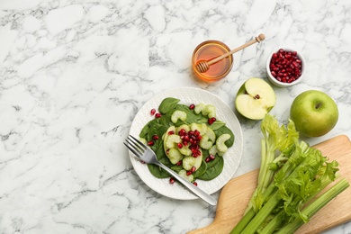 Photo of Delicious fresh celery salad served on white marble table, flat lay. Space for text