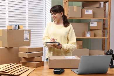 Parcel packing. Post office worker writing notes indoors