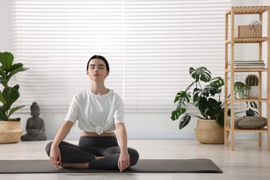 Photo of Beautiful girl meditating on mat in yoga studio