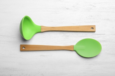 Photo of Different kitchen utensils on wooden background, top view